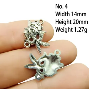 Detailed close-up of fish-shaped antique silver alloy charm showing scales and size