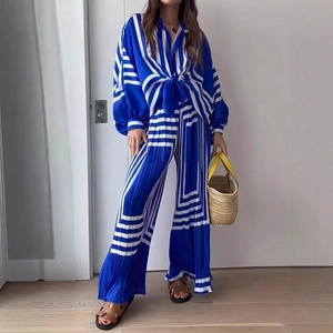 Detail of blue and white geometric striped pleated fabric on a long sleeve shirt set