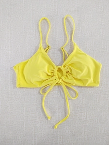 Detail of yellow halter bikini top with metallic ring cutout and adjustable ties