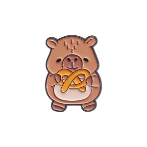 Cute Capybara enamel pin featuring a standing capybara holding a yellow pretzel