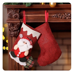 Close-up of burlap Christmas stockings with 3D Santa Claus hanging on a wooden fireplace