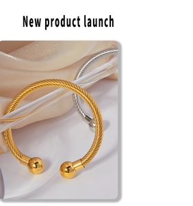 Detail of gold and silver twisted cable bangles with polished metal beads on silk