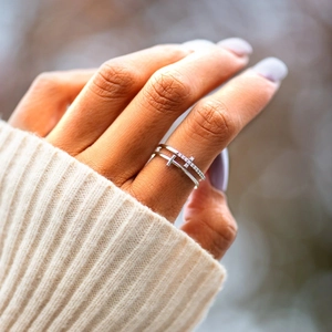 Detail of a double-layered silver ring with sparkling zircon inlay worn by a model