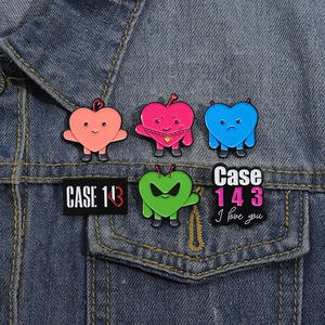Set of six colorful heart emoji enamel pins on a denim jacket featuring CASE 143 text