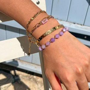 Close-up of layered gold butterfly bangle, amethyst beads, and LOVE charm bracelet set