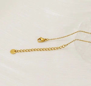 Detail of gold stainless steel necklace clasp and S.Steel engraved tag on pearl chain