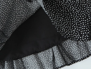 Detail der Polka-Dot-Chiffon-Stoffstruktur mit schwarzem Innenfutter für französischen Rock
