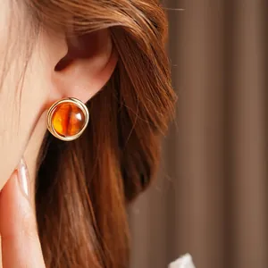 Retro amber resin round stud earrings with gold wire wrap for a luxurious vintage look
