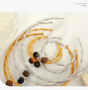 Detailed shot of bamboo style gold and silver collars with natural stone bead accents