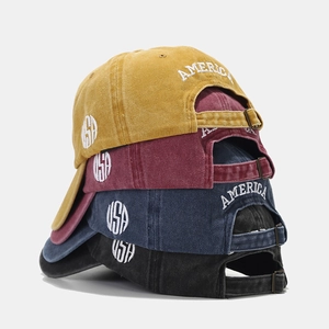 Washed cotton baseball caps with USA embroidery in multiple colors stacked on a plain background