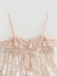 Detail of pink sequined camisole top featuring delicate ruffle trim and thin straps
