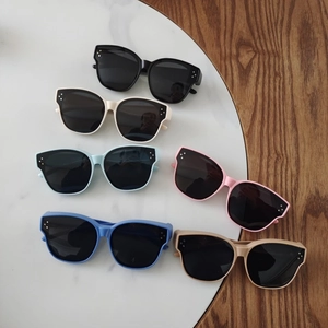 Flat lay of polarized kids sunglasses in six colors on marble and wood surface