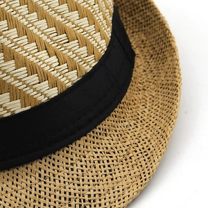 Close-up of the breathable herringbone weave texture and black grosgrain band on the straw hat