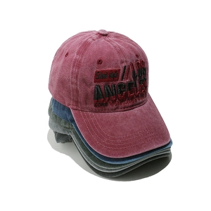 Close-up of stacked Los Angeles embroidered washed cotton baseball caps in burgundy and blue
