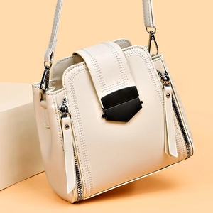 Minimalist beige soft leather crossbody bag with geometric buckle and side zippers