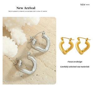 Detailed view of minimalist gold and silver twisted heart C-shaped stud earrings