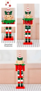 Detail of wooden nutcracker elf with candy cane, red and green painted festive ornament