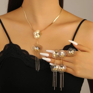Detailed view of floral gold-plated jewelry set with long tassels on a female model