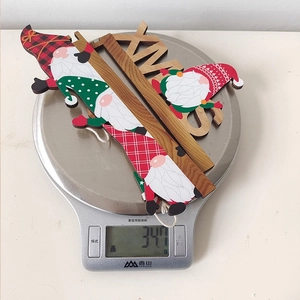 Weight measurement of wooden XMAS gnome door hangers showing 34.7g on a digital scale
