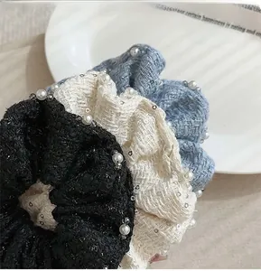 Detail of tweed scrunchies with white pearls and sequins in black, cream and blue colors