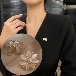 Floral and bow brooches with opals and rhinestones on black suit lapel