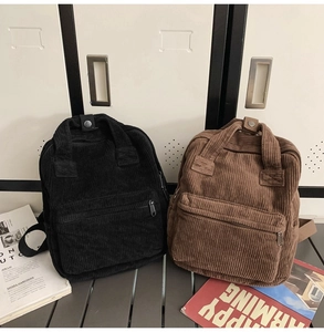 Vue détaillée des sacs à dos en velours côtelé noir et marron sur un banc métallique chic