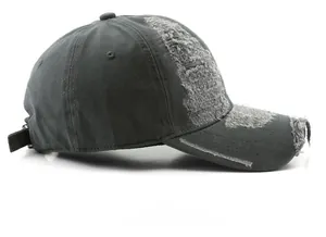 Detail view of distressed edges and torn fabric on charcoal grey vintage baseball cap