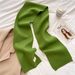 Detailed texture of green knitted scarf with ribbed edges on a stylish cozy layout