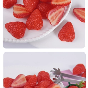 Macro detail of realistic PVC strawberry slices and faux fruit models on a white plate