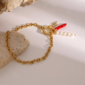 Vue détaillée du bracelet à maillons en or 18 carats avec piment, perle et éclair
