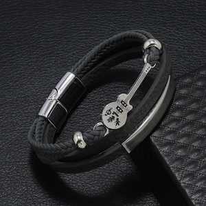 Detailed close-up of a layered leather bracelet featuring a silver guitar-shaped charm