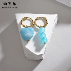 Détails de boucles d'oreilles dorées asymétriques avec cœur bleu et éléments perlés