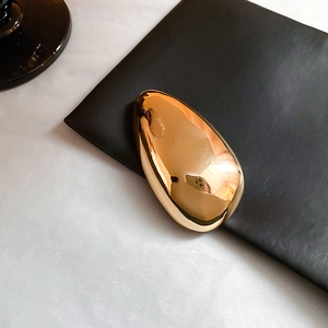 Detailed macro view of the glossy gold plating on an irregular oval brooch accessory