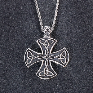 Macro view of silver stainless steel cross pendant with detailed Celtic knot patterns