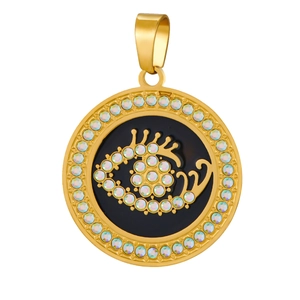 Macro detail of gold-plated evil eye pendant with black enamel and clear crystals
