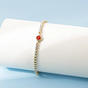 Détail du bracelet tennis en acier doré 18K avec zircon rouge et strass boréaux