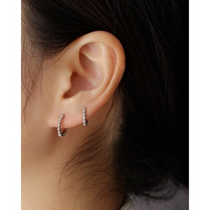 Close-up of minimalist S925 sterling silver beaded hoop earrings worn on the earlobe