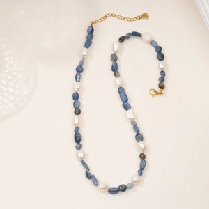 Close-up of natural blue stone beads and white baroque pearls on a gold necklace