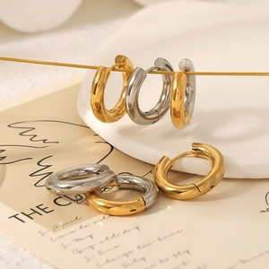 Minimalist hoop earrings in gold and silver stainless steel finish set on white plate