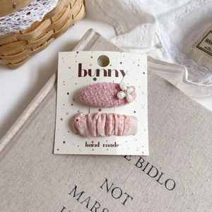 Close-up of pink fabric floral hair clips set on a bunny card for girls hair styling