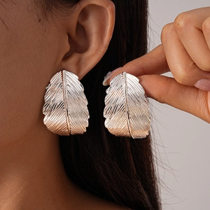 Statement silver feather earrings with intricate metallic texture for a minimalist look