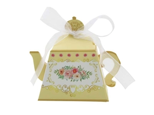 Detailed view of teapot shaped yellow gift box with floral patterns and a white silk ribbon