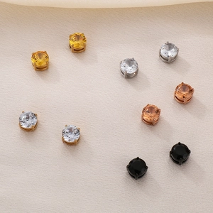 Macro shot of colorful cubic zirconia magnetic stud earrings on textured fabric