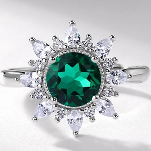Silver sunflower ring with round green emerald center and sparkling clear halo stones