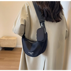 Dettaglio borsa a tracolla in nylon con mini pochette indossata dalla modella