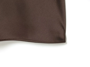 Detail of silk-like satin dress showing fine stitching and smooth coffee brown fabric