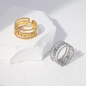 Detail view of gold and silver layered chain rings with beaded texture on stone