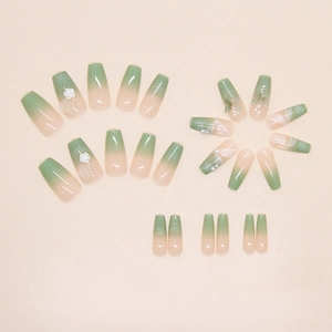 Détail de faux ongles dégradés rose et vert avec fleurs 3D et perles élégantes