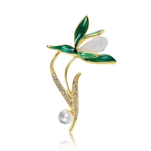 Detailed view of a golden lily of the valley brooch with green enamel and white pearl