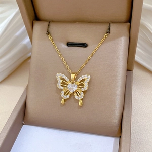 Macro shot of gold butterfly necklace with zircon diamonds and heart crystal inlay